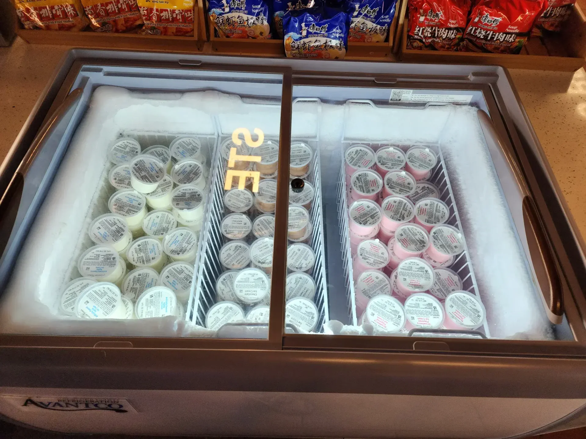 Self-serve ice cream freezer with vanilla and strawberry flavored ice cream cups at Korean BBQ restaurant