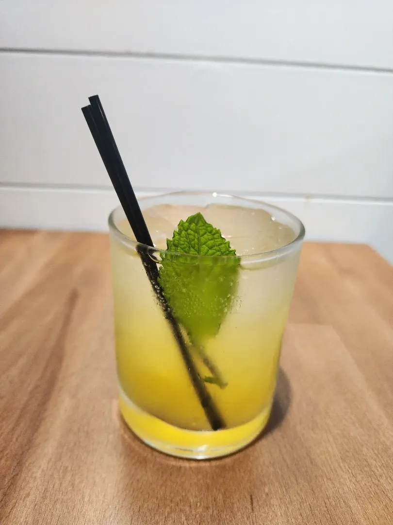 A carbonated drink with some mango and mint.