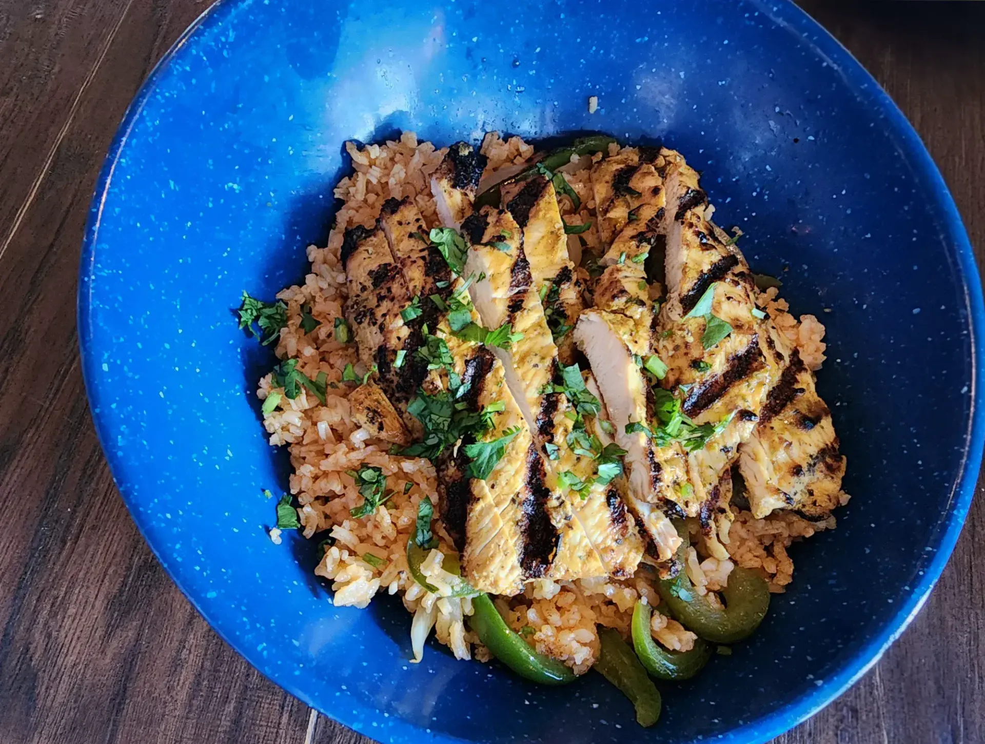 Chicken and rice bowl with garnish and green bell pepper