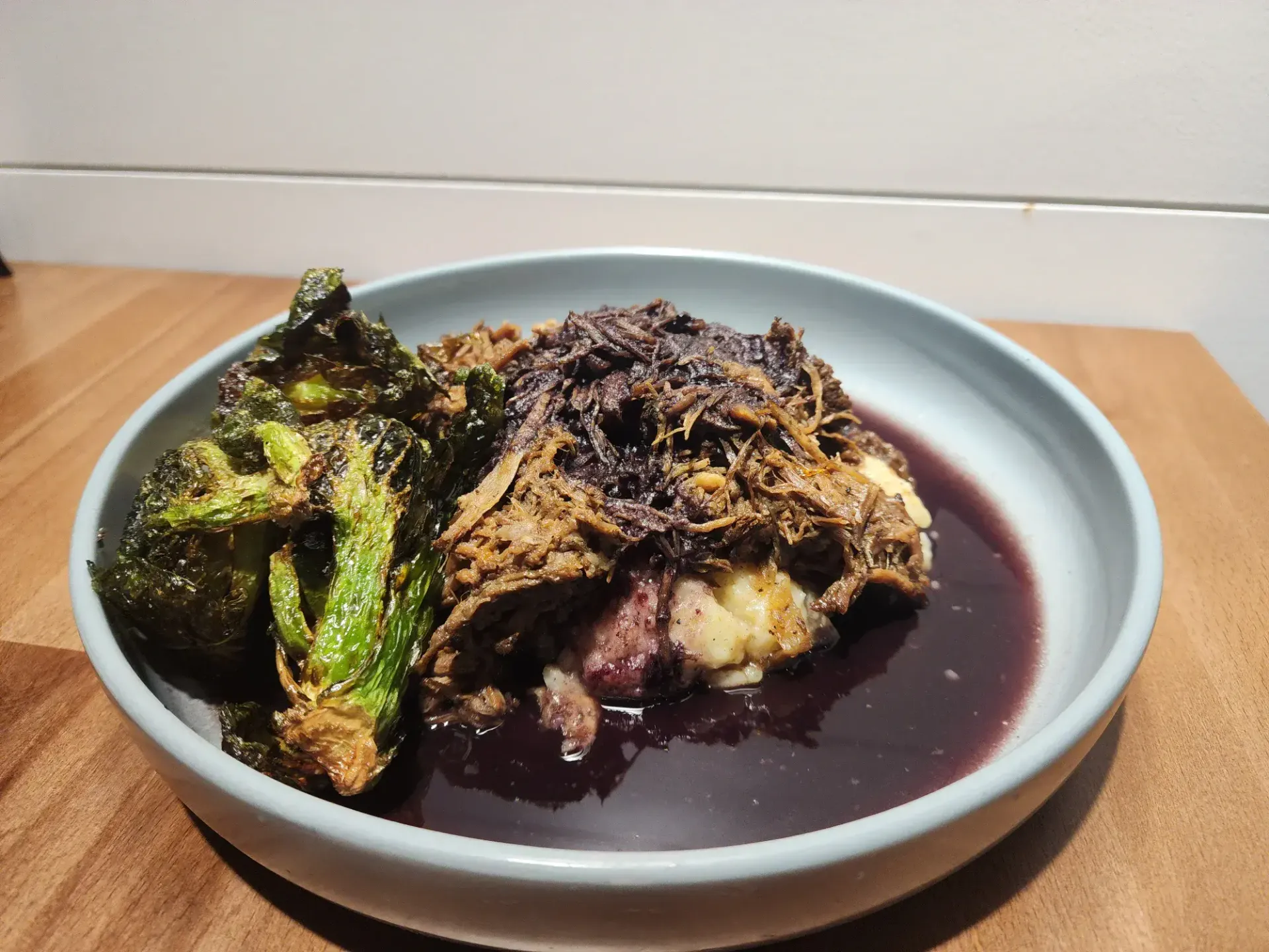 Pulled boneless short rib, mashed potatoes, brussel sprouts, and a win reduction on the bottom.